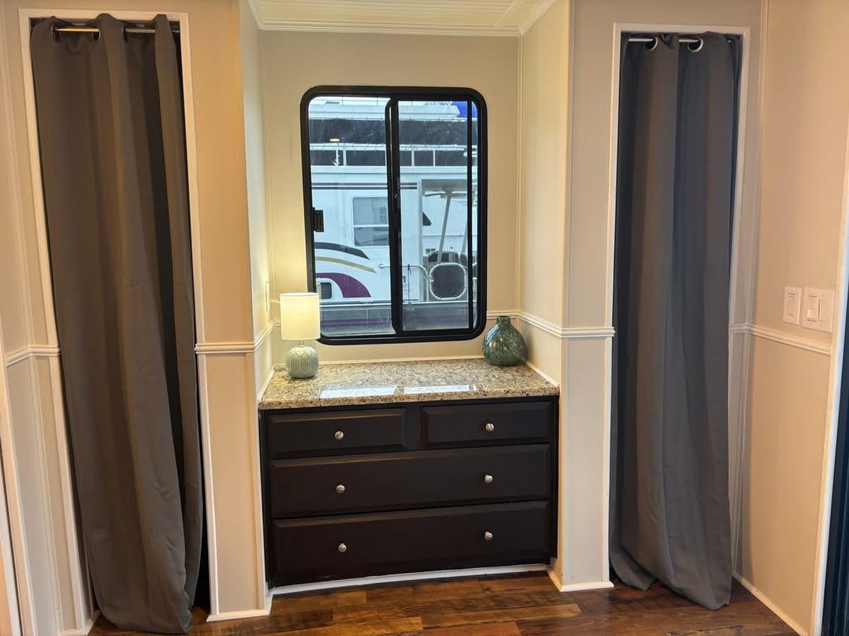 Interior of 1992 Lakeview Houseboat with window, curtains, and dresser.