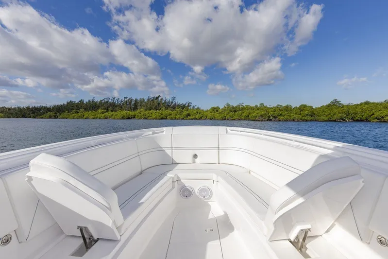  Yacht Photos Pics Manufacturer Provided Image: 2022 Intrepid 345 Nomad FE boat with white seating, on a calm water body.