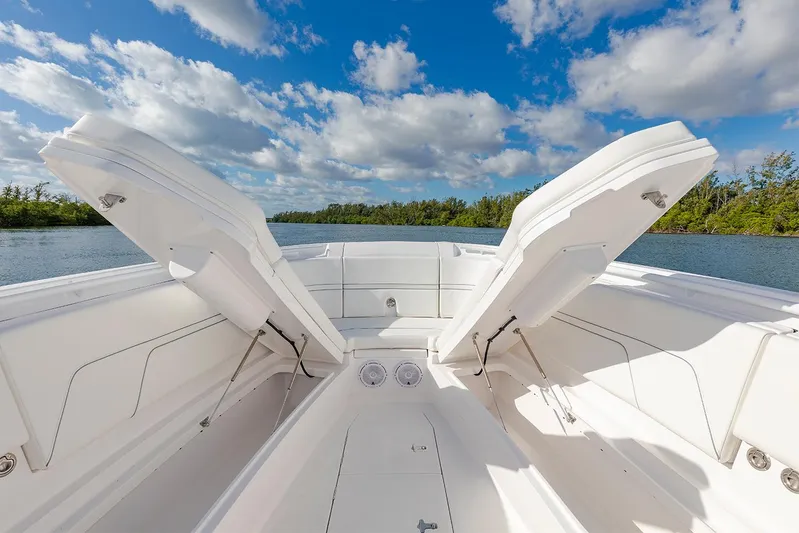  Yacht Photos Pics Manufacturer Provided Image: 2022 Intrepid 345 Nomad FE boat with open storage compartments on a sunny day.