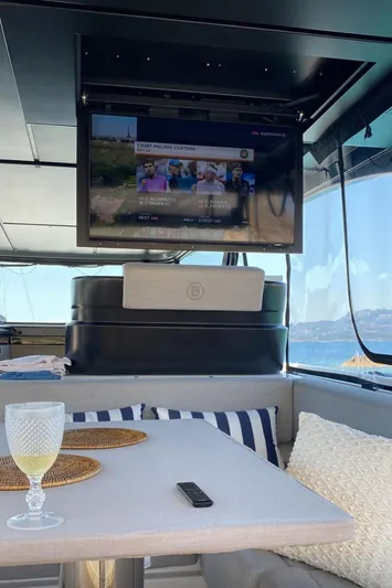  Yacht Photos Pics Luxurious interior of 2024 Bluegame BG54 yacht with TV and elegant dining setup.