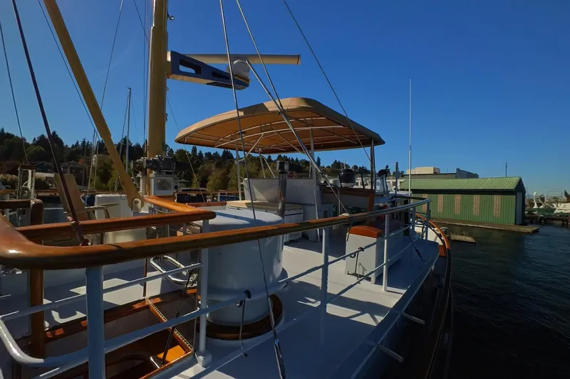  Yacht Photos Pics 1974 Doggersbank 63 yacht docked, featuring wooden railings and canopy under clear blue sky.