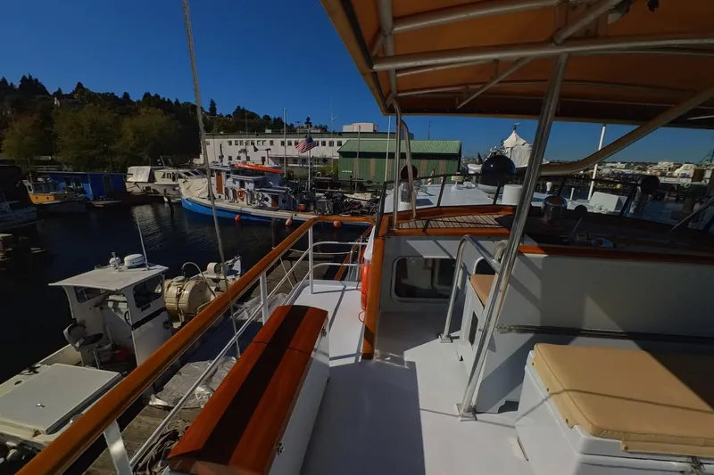  Yacht Photos Pics 1974 Doggersbank 63 yacht docked at a marina, featuring a spacious deck and seating area.
