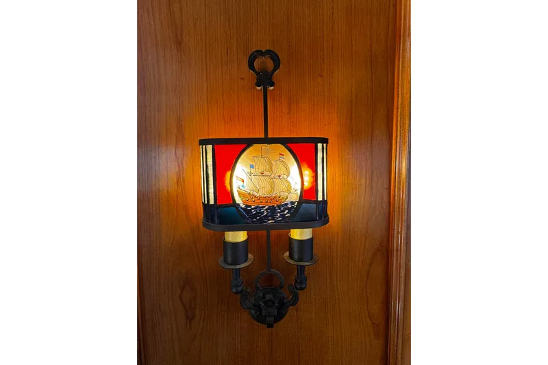  Yacht Photos Pics Vintage nautical-themed wall lamp with ship design on wooden panel.
