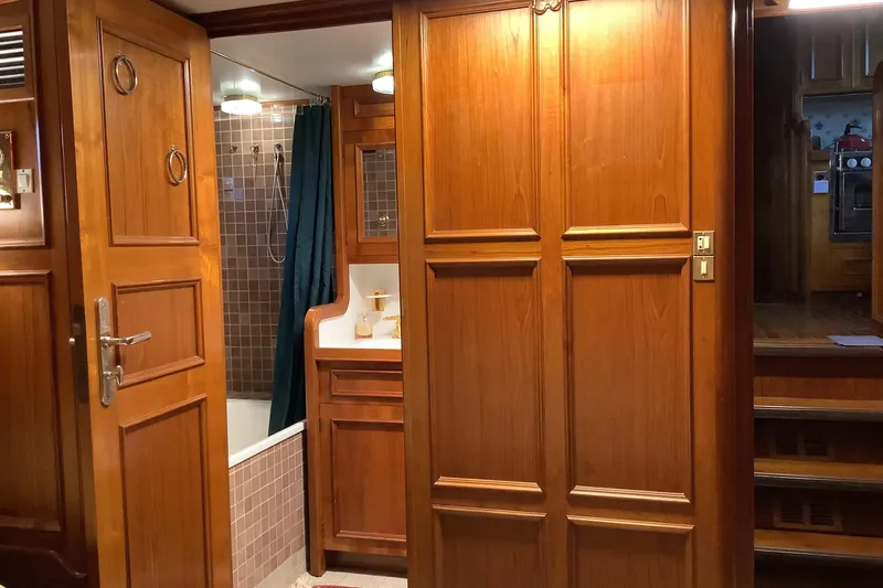  Yacht Photos Pics Wood-paneled bathroom interior on a 1974 Doggersbank 63 yacht, featuring a shower and vanity.
