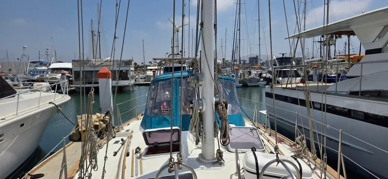  Yacht Photos Pics 1987 Tayana Center Cockpit sailboat docked in a marina, surrounded by other boats.