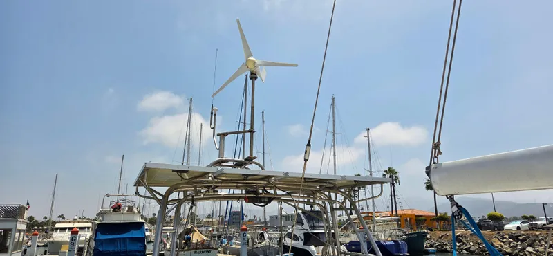  Yacht Photos Pics 1987 Tayana Center Cockpit sailboat with wind turbine at marina under clear sky.