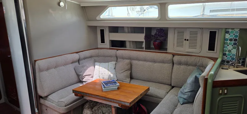  Yacht Photos Pics Cozy 1987 Tayana Center Cockpit interior with cushioned seating and wooden table.