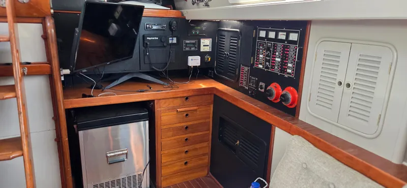  Yacht Photos Pics 1987 Tayana Center Cockpit interior with navigation equipment, control panel, and compact fridge.