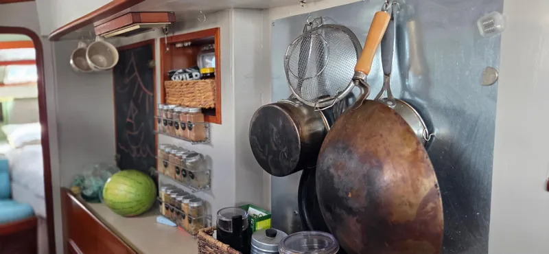  Yacht Photos Pics 1987 Tayana Center Cockpit kitchen with hanging pots, spices, and a watermelon.
