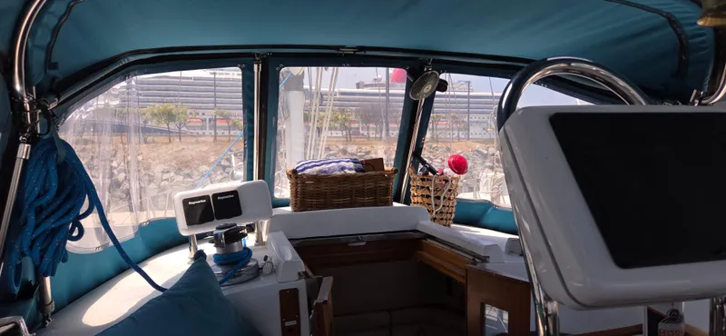  Yacht Photos Pics Interior view of 1987 Tayana Center Cockpit sailboat with blue canopy and navigation equipment.