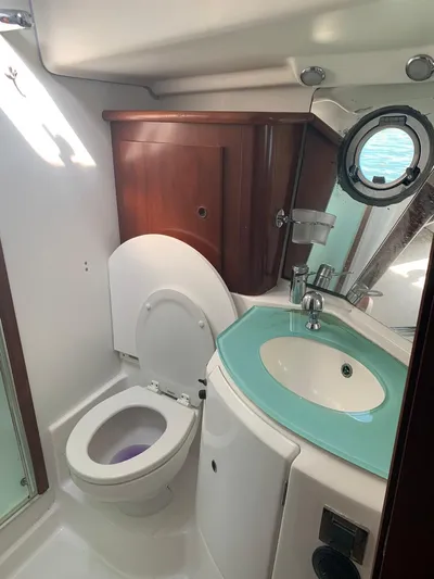  Yacht Photos Pics 2006 Beneteau Swift Trawler 42 bathroom with toilet, sink, and porthole window.