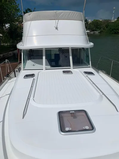  Yacht Photos Pics 2006 Beneteau Swift Trawler 42, white exterior, docked near lush greenery.