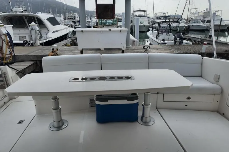  Yacht Photos Pics 2009 Riviera 4700 Sport Yacht cockpit with seating and table, docked at marina.