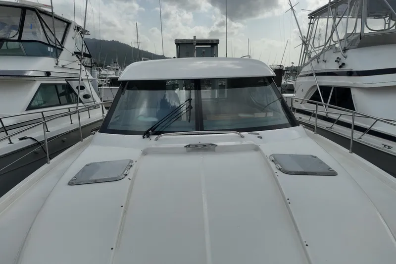  Yacht Photos Pics 2009 Riviera 4700 Sport Yacht docked between other boats in a marina.