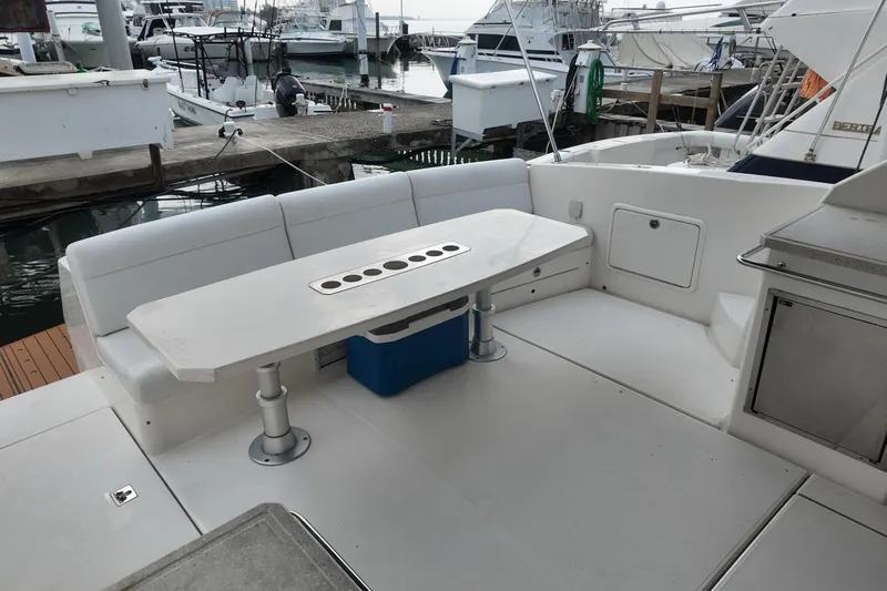  Yacht Photos Pics 2009 Riviera 4700 Sport Yacht with outdoor seating and table at marina.