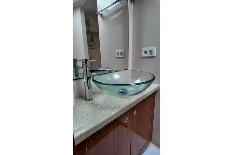  Yacht Photos Pics Glass vessel sink in 2009 Riviera 4700 Sport Yacht bathroom, featuring modern faucet and wooden cabinetry.