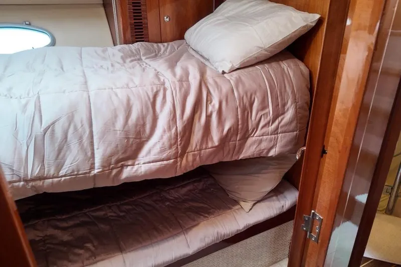  Yacht Photos Pics Interior of 2009 Riviera 4700 Sport Yacht with cozy bunk beds and wooden finish.