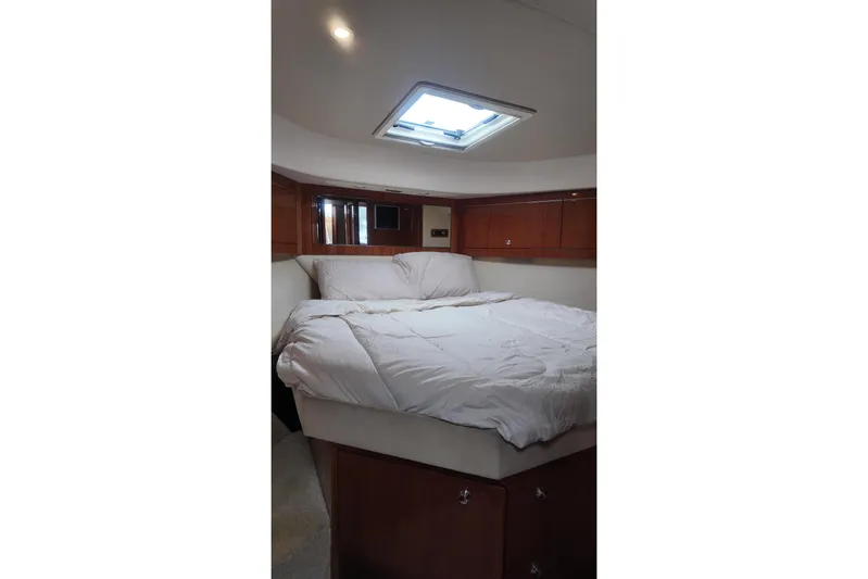  Yacht Photos Pics Luxurious bedroom interior of 2009 Riviera 4700 Sport Yacht with skylight and wooden cabinetry.