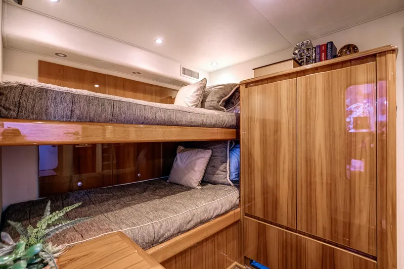 Pipe Dreamer Yacht Photos Pics Luxurious cabin interior of 2015 Viking 70 Convertible yacht with wooden finishes and bunk beds.