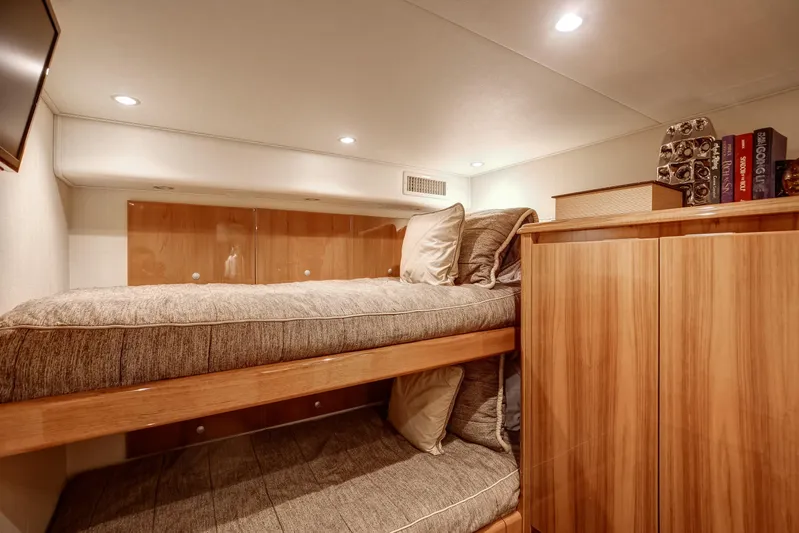 Pipe Dreamer Yacht Photos Pics Cozy cabin interior of 2015 Viking 70 Convertible yacht with bunk beds and wooden cabinetry.
