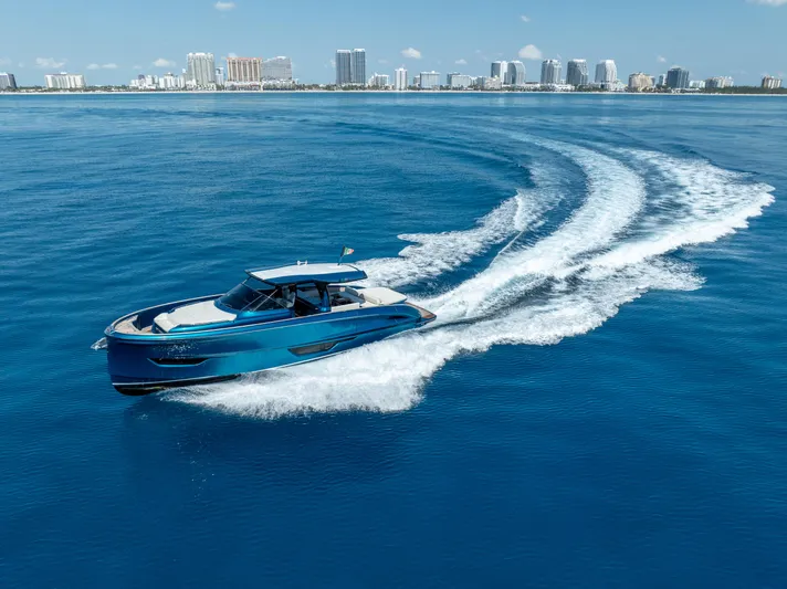  Yacht Photos Pics 2024 Solaris Power 52 Open yacht cruising on blue ocean near city skyline.