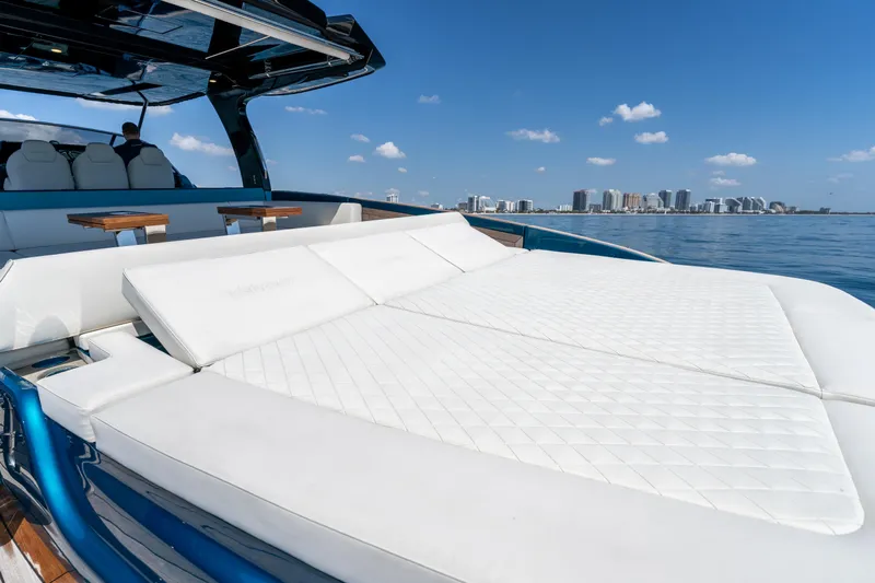  Yacht Photos Pics 2024 Solaris Power 52 Open yacht with luxurious sunbed, ocean view, and city skyline.