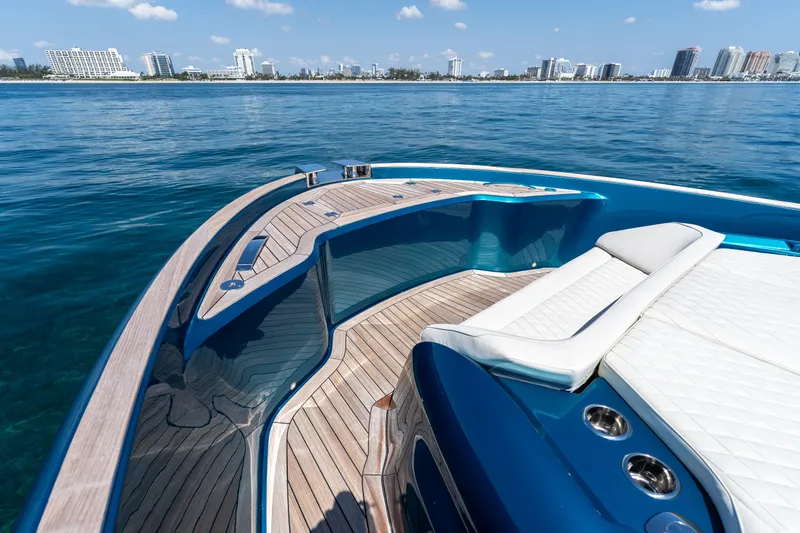  Yacht Photos Pics 2024 Solaris Power 52 Open yacht with sleek deck design and luxurious seating, overlooking a coastal cityscape.