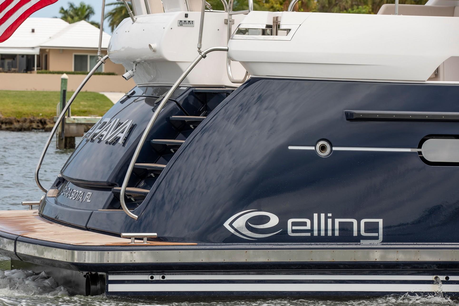 2025 Elling E6 Ultimate yacht, sleek design, docked near waterfront homes.