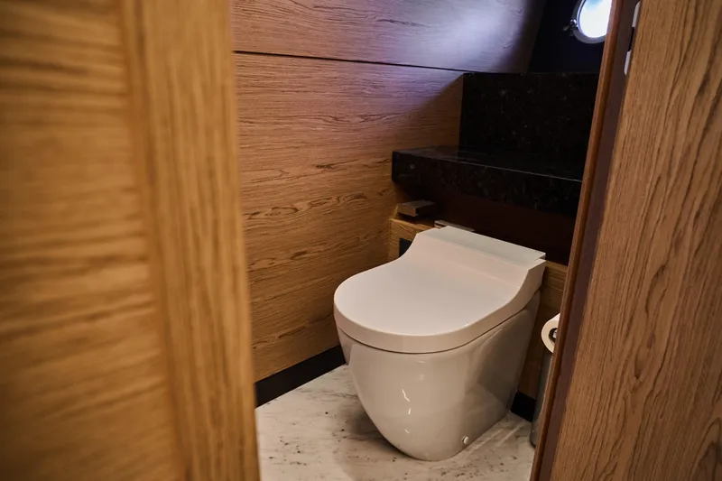  Yacht Photos Pics Luxurious bathroom in 2023 Ferretti Yachts 920, featuring modern toilet and wood paneling.