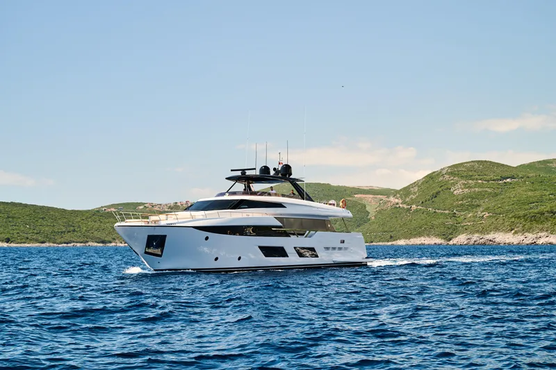  Yacht Photos Pics 2023 Ferretti Yachts 920 cruising on blue waters near a scenic coastline.