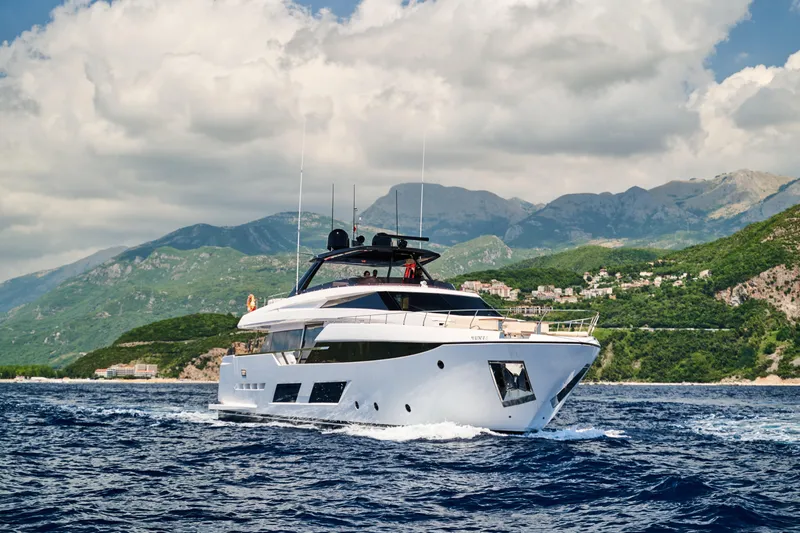  Yacht Photos Pics 2023 Ferretti Yachts 920 cruising on blue waters with scenic mountain backdrop.