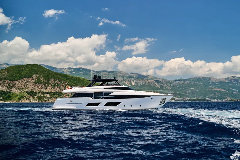  Yacht Photos Pics 2023 Ferretti Yachts 920 cruising on blue ocean with scenic mountain backdrop.