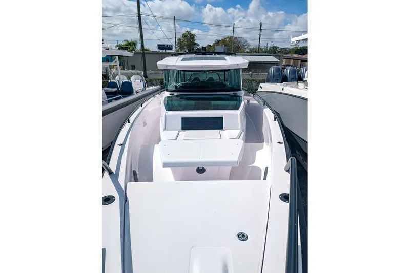  Yacht Photos Pics 2024 Axopar 37XC CROSS CABIN BRABUS Trim boat, sleek design, docked under blue sky.