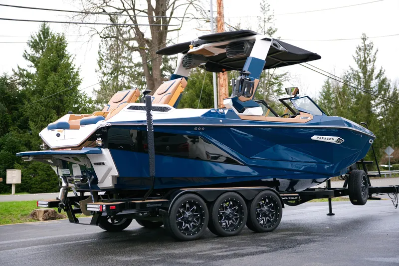  Yacht Photos Pics 2024 Nautique Super Air Nautique G23 Paragon boat on trailer, blue and tan design.