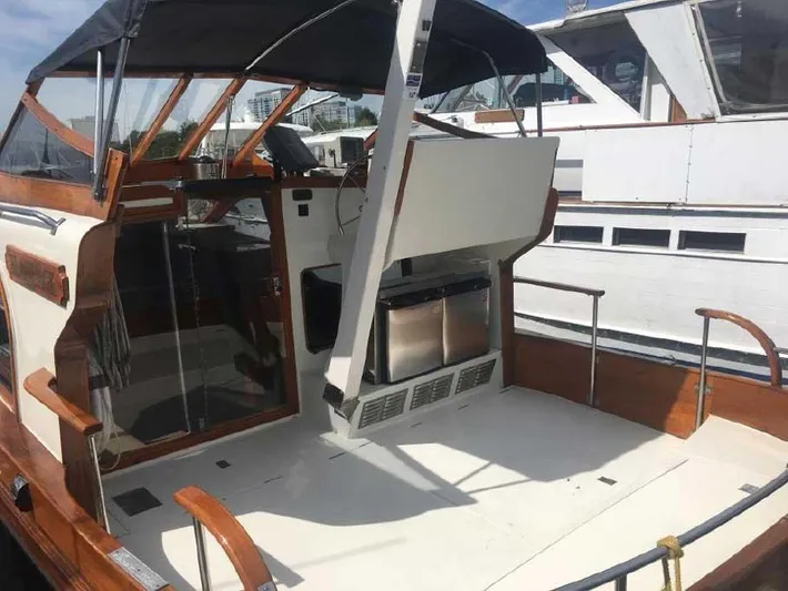 Blackjack Yacht Photos Pics 1984 Midnight Lace Rumrunner boat with open deck and wooden accents, docked at marina.