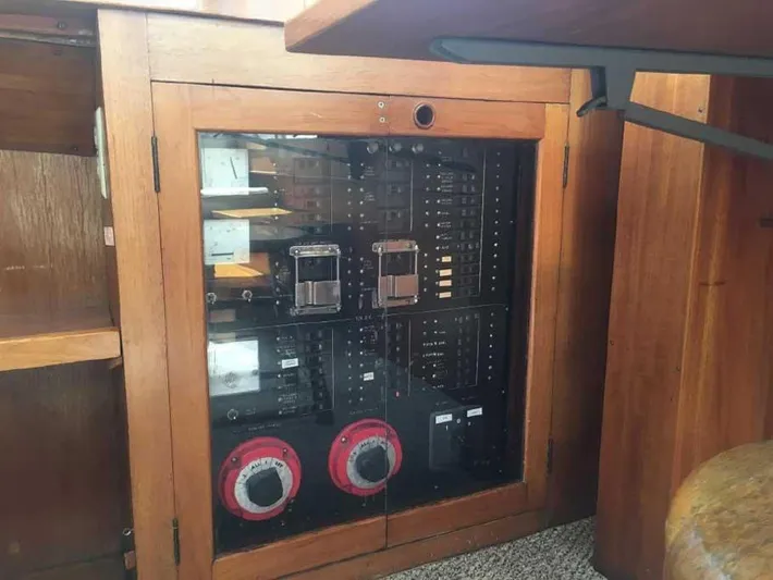 Blackjack Yacht Photos Pics Electrical control panel in a 1984 Midnight Lace Rumrunner boat, featuring wooden cabinetry.