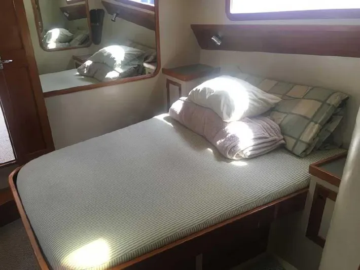 Blackjack Yacht Photos Pics Cozy cabin bedroom in 1984 Midnight Lace Rumrunner yacht with striped bedding and wooden accents.