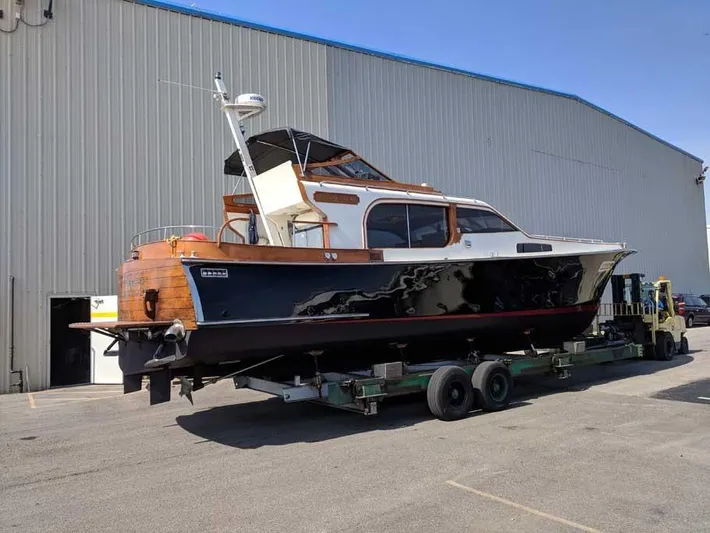 Blackjack Yacht Photos Pics 1984 Midnight Lace Rumrunner boat on trailer outside large warehouse.