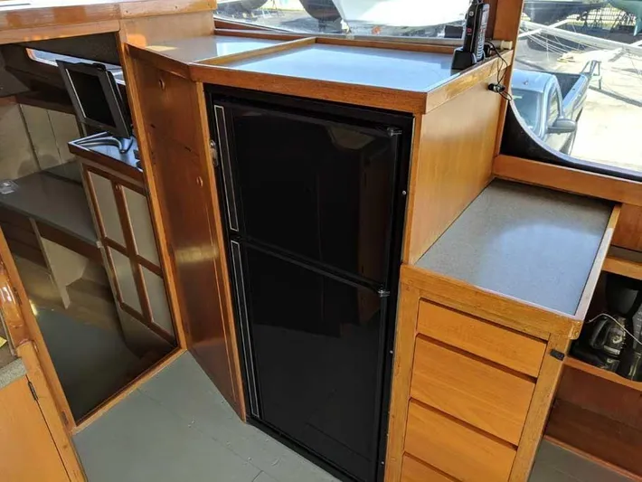 Blackjack Yacht Photos Pics 1984 Midnight Lace Rumrunner yacht interior with wooden cabinetry and black refrigerator.