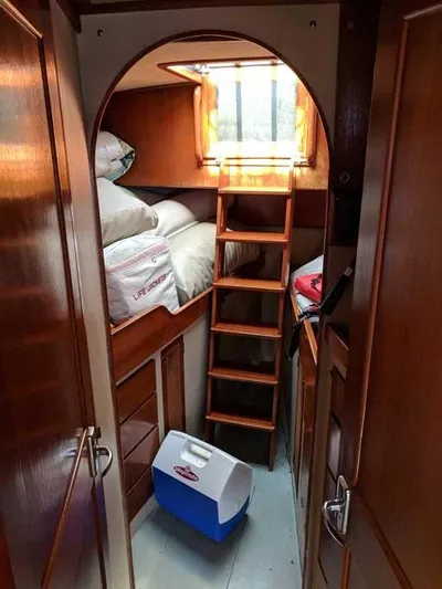 Blackjack Yacht Photos Pics Cozy cabin interior of 1984 Midnight Lace Rumrunner with wooden ladder and storage.
