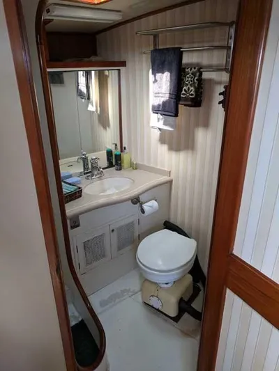 Blackjack Yacht Photos Pics 1984 Midnight Lace Rumrunner yacht bathroom with sink, toilet, mirror, and towel rack.