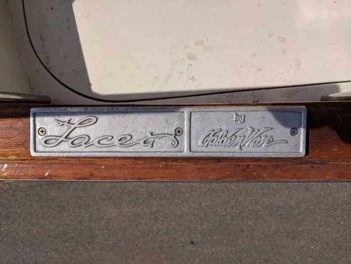 Blackjack Yacht Photos Pics 1984 Midnight Lace Rumrunner nameplate on wooden surface, featuring elegant script design.