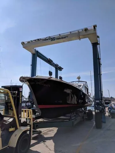 Blackjack Yacht Photos Pics 1984 Midnight Lace Rumrunner boat on a marine travel lift at a shipyard.