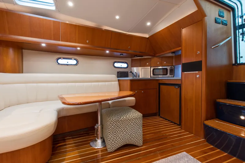 Forever Friday Yacht Photos Pics 2005 Tiara Yachts 3600 Sovran interior with wood finish, kitchenette, and seating area.