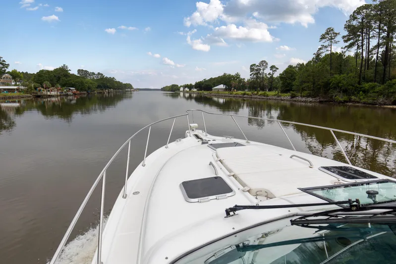 Forever Friday Yacht Photos Pics 2005 Tiara Yachts 3600 Sovran cruising on a serene river with lush greenery.