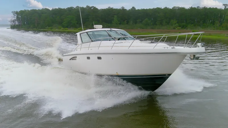 Forever Friday Yacht Photos Pics 2005 Tiara Yachts 3600 Sovran cruising on a river with lush green forest backdrop.