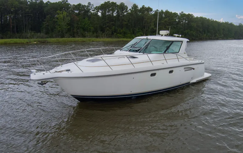 Forever Friday Yacht Photos Pics 2005 Tiara Yachts 3600 Sovran cruising on a calm river with forested background.