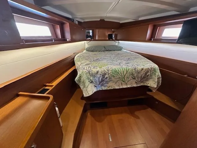 Lucky Yacht Photos Pics Cozy cabin interior of 2014 Beneteau Oceanis 45 sailboat with bed and wooden finish.