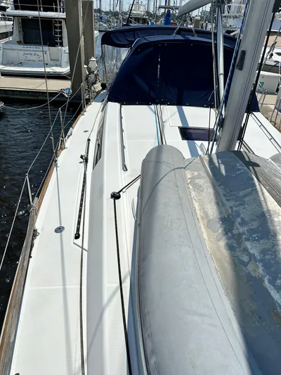 Lucky Yacht Photos Pics 2014 Beneteau Oceanis 45 sailboat deck with blue canopy, docked at marina.