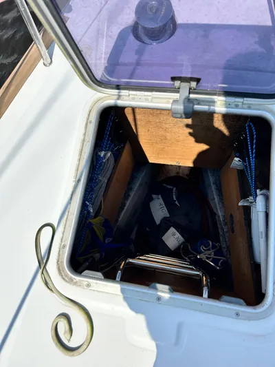Lucky Yacht Photos Pics Open hatch on 2014 Beneteau Oceanis 45 sailboat, showing storage compartment with ropes and equipment.